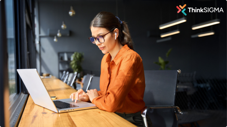 Silo working shown be a professional woman in an orange shirt in an office working alone