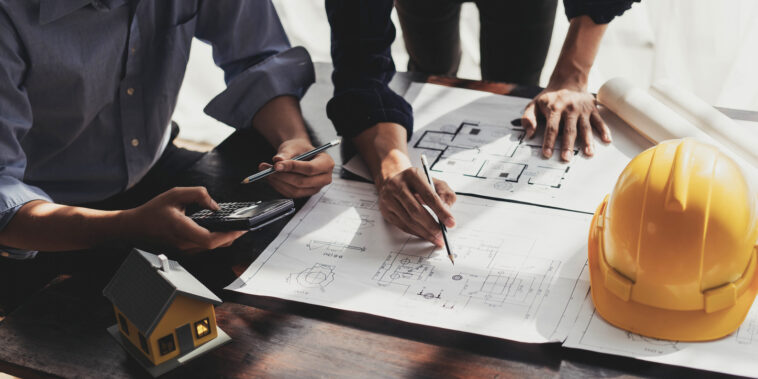 Commercial Management in Construction shown by workers on site focusing on plans