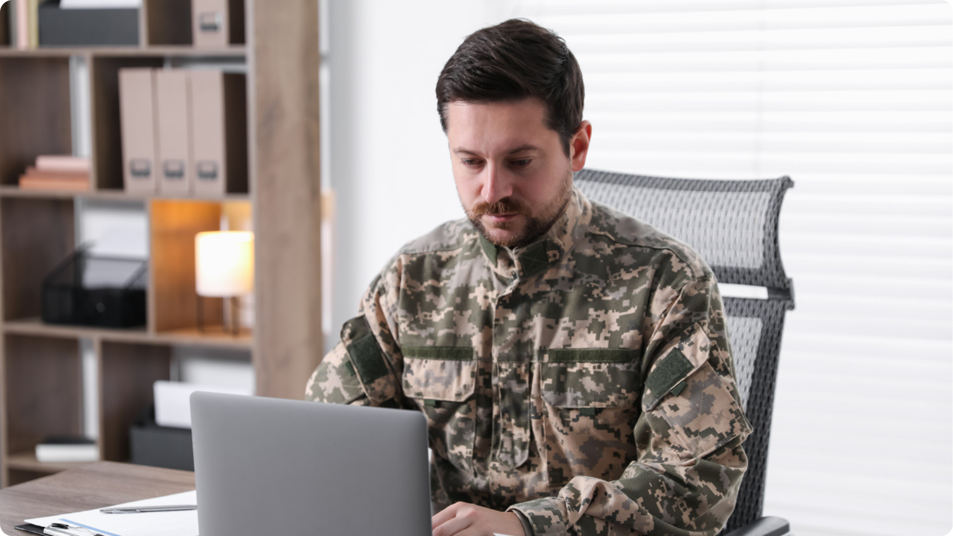 Understanding MOD Procurement shown by a professional in uniform using a laptop