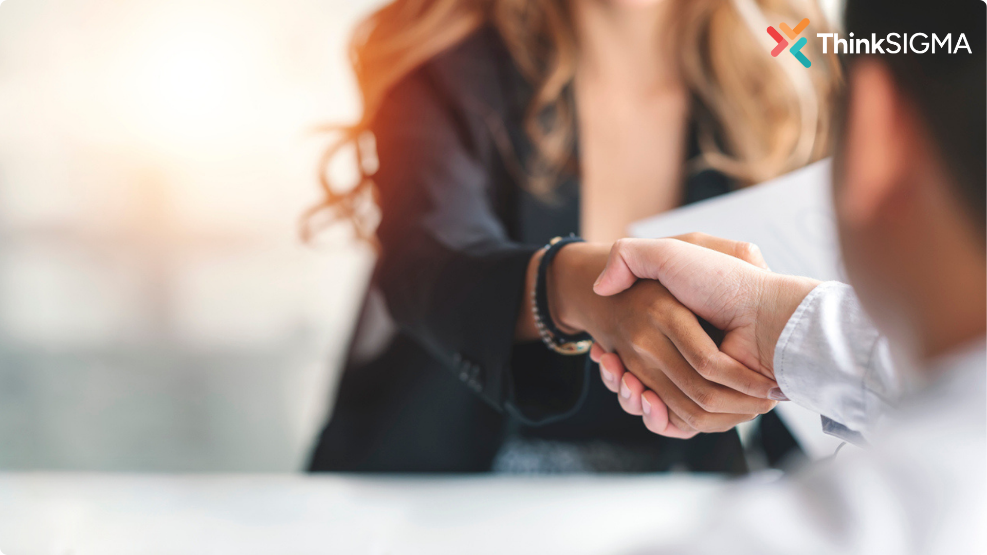 How to Improve Commercial Awareness - shown by a woman shaking hands with a man over a contract